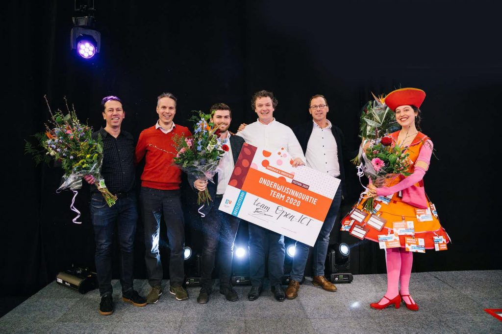 Docenten van Open-ICT poseren met de prijs en bloemen